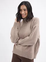 Buzo de tejido de punto color beige, con cuello alto y mangas largas con puños acanalados.