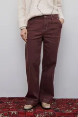 Pantalón jean de corte wide leg en color bordó, de tiro medio con bolsillos delanteros y traseros.