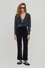 Pantalón de terciopelo negro, de corte recto, tiro medio-alto, pretina con ojales para cinturón, bolsillos laterales y traseros de ojal.