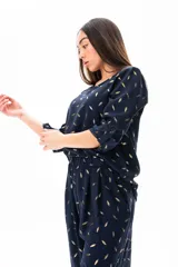 Blusa azul marino con estampado de hojas doradas, de corte holgado y mangas 3/4 con botón.