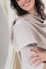 Ruana tejida en punto acanalado, con diseño bicolor en tonos crudo y beige, de caída fluida y envolvente.