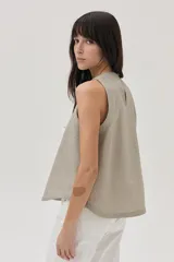 Top sin mangas de lino metalizado color beige, con escote redondo y corte holgado.