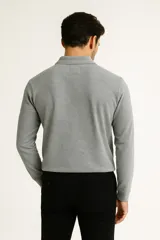 Remera de manga larga color negro, confeccionada en algodón, con cuello tipo polo y tapeta de tres botones.