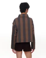 Chaqueta corta de gabardina de algodón con estampado a rayas en tonos marrón y gris. Tiene cuello alto, cierre metálico frontal, bolsillos de parche y forro interior.