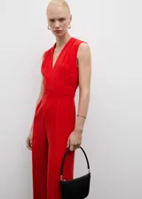 Mono largo rojo de tejido fluido con escote de pico, tirantes anchos, detalle cruzado en la cintura y cierre de cremallera invisible en la parte posterior.