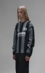 Sweater de punto con diseño a rayas verticales en negro y gris, cuello redondo y mangas largas. Presenta un estampado gráfico frontal con estilo deportivo retro que incluye el texto 'Ravers' y el número '90'. Cuenta con terminaciones en punto rib en cuello, puños y ruedo.