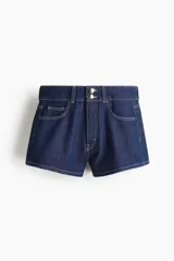 Short de denim azul de tiro alto, confeccionado en algodón rígido con diseño de cinco bolsillos, corte holgado, cierre y doble botón metálico en la cintura.