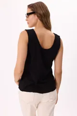 Musculosa negra de algodón liviano, suave y fresco, con cuello amplio y terminaciones sutiles.