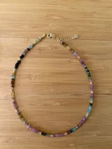 Gargantilla corta con cuentas de turmalina multicolor y detalles dorados.