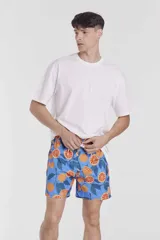 Short de baño azul con estampado de naranjas y hojas verdes.