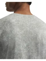 Remera deportiva de manga corta con tecnología Iso-Chill que disipa el calor corporal. Presenta un estampado jaspeado en tonos grisáceos, perforaciones láser estratégicas para ventilación y aberturas laterales en el bajo.