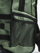 Mochila de estilo táctico color verde oliva, con múltiples correas ajustables frontales, hebillas de cierre rápido y bolsillos laterales de red. Cuenta con compartimentos principales con cierre y correas de hombro acolchadas.