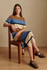Vestido midi de punto con diseño de rayas horizontales en tonos marrón, azul y beige. Presenta cuello redondo, mangas cortas y un corte recto con aberturas laterales en el ruedo.