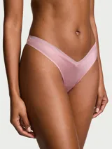 Tanga de tiro bajo color rosado, con diseño en V al frente, corte de pierna alto y detalles de malla transparente.