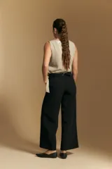 Pantalón de vestir negro de corte ancho y tiro alto, con silueta fluida y diseño minimalista.