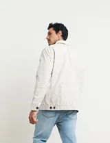 Campera azul oscuro con cierre frontal, cuello clásico y bolsillos laterales.