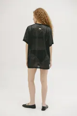 Remerón negro de tejido calado con mangas cortas y corte oversize.