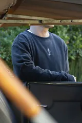 Buzo negro con efecto lavado y estampado en la espalda de un sol, hongos y flores.