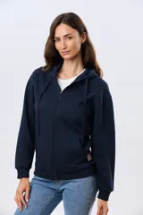 Campera deportiva azul marino con capucha y cierre frontal, confeccionada en algodón con felpa. Presenta cordones ajustables al tono y puños ribeteados.