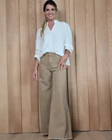 Pantalón de jean color beige, de corte wide leg con tiro medio y ruedo desflecado.