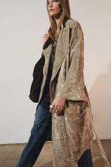 Kimono de terciopelo con cuello solapa y manga larga. Presenta bordados a tono en toda la prenda, cinturón ajustable del mismo tejido y acabados desflecados. Incluye forro interior.