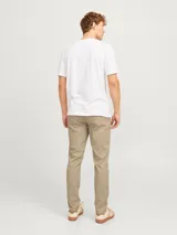 Pantalón chino slim de tiro medio color beige, con cierre de cremallera y bolsillos laterales.