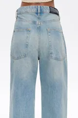 Pantalón vaquero celeste de corte wide leg, tiro bajo, con cierre frontal con botón denim y cinco bolsillos.