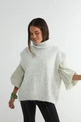Chaleco de punto con cuello alto, diseño sin mangas y corte holgado, confeccionado en una mezcla de fibras con textura suave.