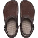 Zueco Crocs Yukon Vista II color gris oscuro, con parte superior de material sintético que simula cuero, costuras decorativas en el empeine y orificios de ventilación frontales. Posee correa ajustable en el talón de color gris claro.