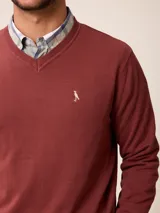 Sweater de punto con cuello en V, manga larga y puños acanalados. Presenta un pequeño logo bordado en el pecho.