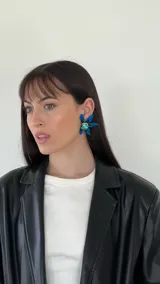 Aros colgantes con forma de flor, con pétalos azules y centro con strass verde.