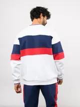 Buzo de cuello redondo confeccionado en felpa, con diseño de bloques de color en azul, rojo y blanco. Presenta el logo de Umbro y el escudo del Club Nacional de Football bordados en el frente.