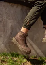 Bota corta de cuero color marrón oscuro con cierre frontal, plataforma y suela de goma.