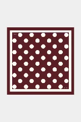 Pañuelo cuadrado de seda con estampado de lunares blancos sobre fondo bordó y borde contrastante.
