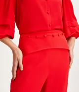 Pantalón de vestir rojo, de corte recto, con cintura media y botones forrados.