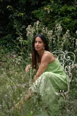 Conjunto de dos piezas compuesto por un crop top de breteles anchos y una pollera midi, ambos en color azul con detalles de bordado floral blanco en el ruedo y el lateral del top.