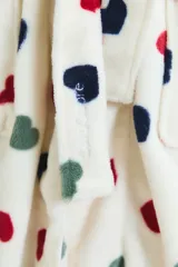 Bata de estar por casa confeccionada en tejido de poliéster suave, con diseño estampado de corazones en colores rojo, negro y verde sobre fondo blanco. Presenta un corte holgado, mangas largas y bolsillos frontales.