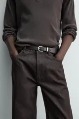 Jeans flare fit de denim negro, con tiro medio, corte ajustado en la parte superior y ligeramente acampanado desde la rodilla. Diseño de cinco bolsillos y cierre frontal con botones.