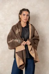 Pashmina reversible de textura suave y caída fluida, con diseño estampado de hojas de ginkgo. Presenta un lado en color marrón con estampado beige y el reverso en color beige con estampado marrón, finalizando en sus extremos con flecos cortos deshilachados.
