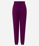 Pantalón jogger de tiro alto confeccionado en crepé color violeta. Presenta pliegues frontales, bolsillos laterales tipo cuchillo y puños elásticos en los tobillos.