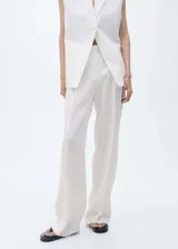 Pantalón de lino color blanco, con tiro medio, diseño de pernera recta y cierre frontal con botón, gancho y cremallera ocultos.