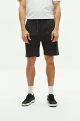 Short de felpa color negro con textura, bolsillos laterales y uno trasero. Cuenta con cintura regulable con cordón y logo bordado en la pierna izquierda.