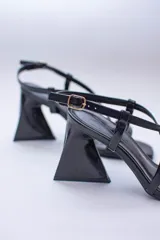 Sandalia negra de tacón con punta cuadrada y tiras finas cruzadas en el empeine.