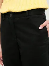Pantalón chino de corte slim, color negro, con cierre de botón y cremallera, diseño de cuatro bolsillos y logo bordado en la parte trasera.
