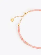 Collar corto realizado con cuentas de piedras naturales en tonos rosados, con dije colgante dorado en forma de fruta y cadena regulable.