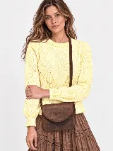 Sweater de hilo tejido color amarillo, con cuello redondo, calce cómodo y mangas amplias con puños acanalados. Presenta detalles de trenzas y flecos en el frente.