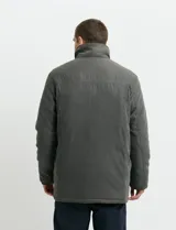 Campera de estilo Harrington en color verde oscuro, con cuello alto, cierre frontal y solapa con botones.