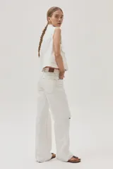 Pantalón de jean blanco, de calce recto y tiro medio-alto. Cuenta con un corte en la rodilla y ruedo desflecado.