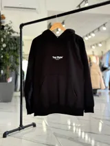 Canguro negro oversize con capucha y gran estampado blanco en la espalda con el texto "Top Style", "Dream big. Work hard. Make it real.", "SINCE 2021" y un código de barras.