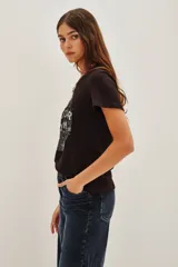 Remera de algodón color negro con estampa frontal circular que incluye la frase 'Rockstar Dreams' y estrellas decorativas.